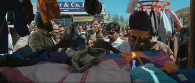 a crowd of people standing around a pile of clothes