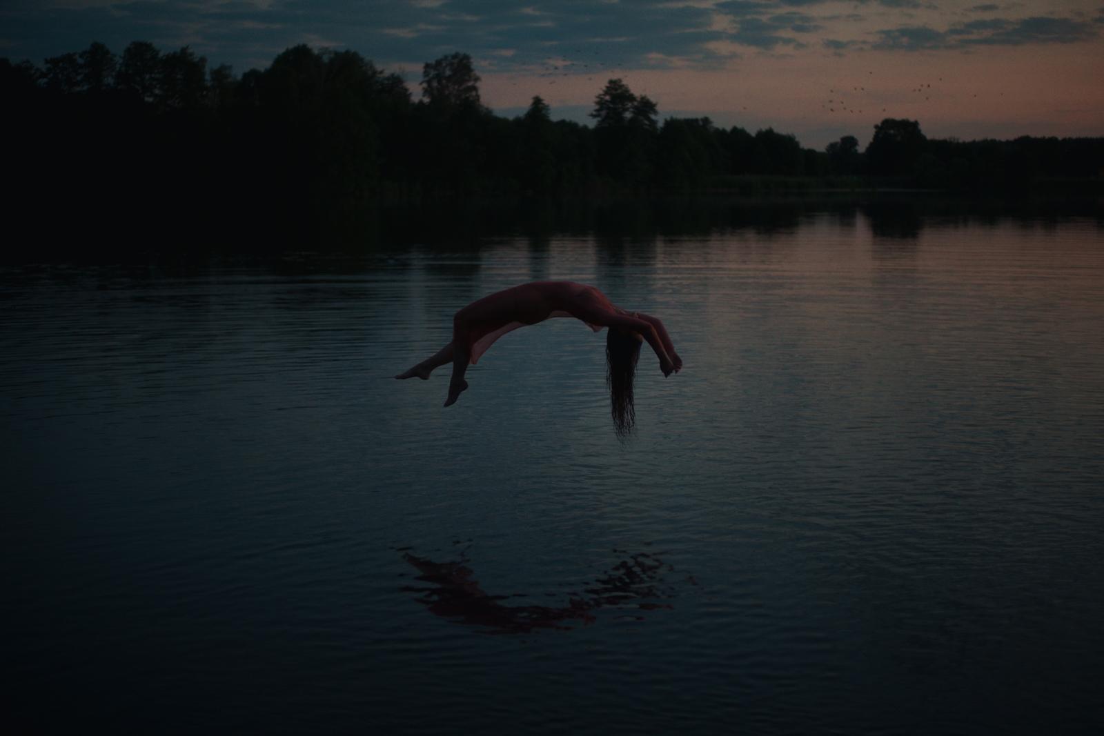 a large bird flying over a body of water