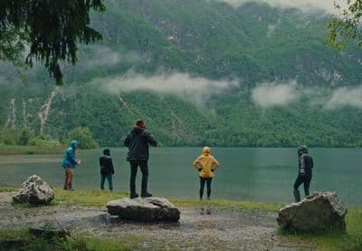 a group of people standing on top of a lush green hillside