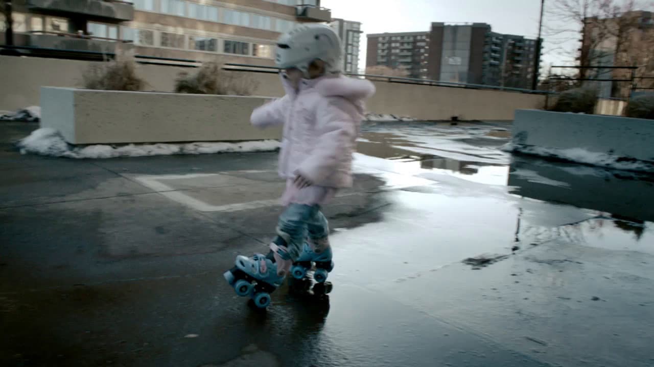 a little girl riding a skateboard down a street