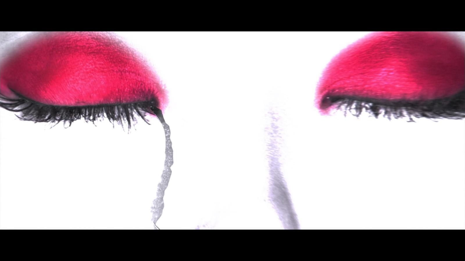 a close up of a woman's eye with red lashes