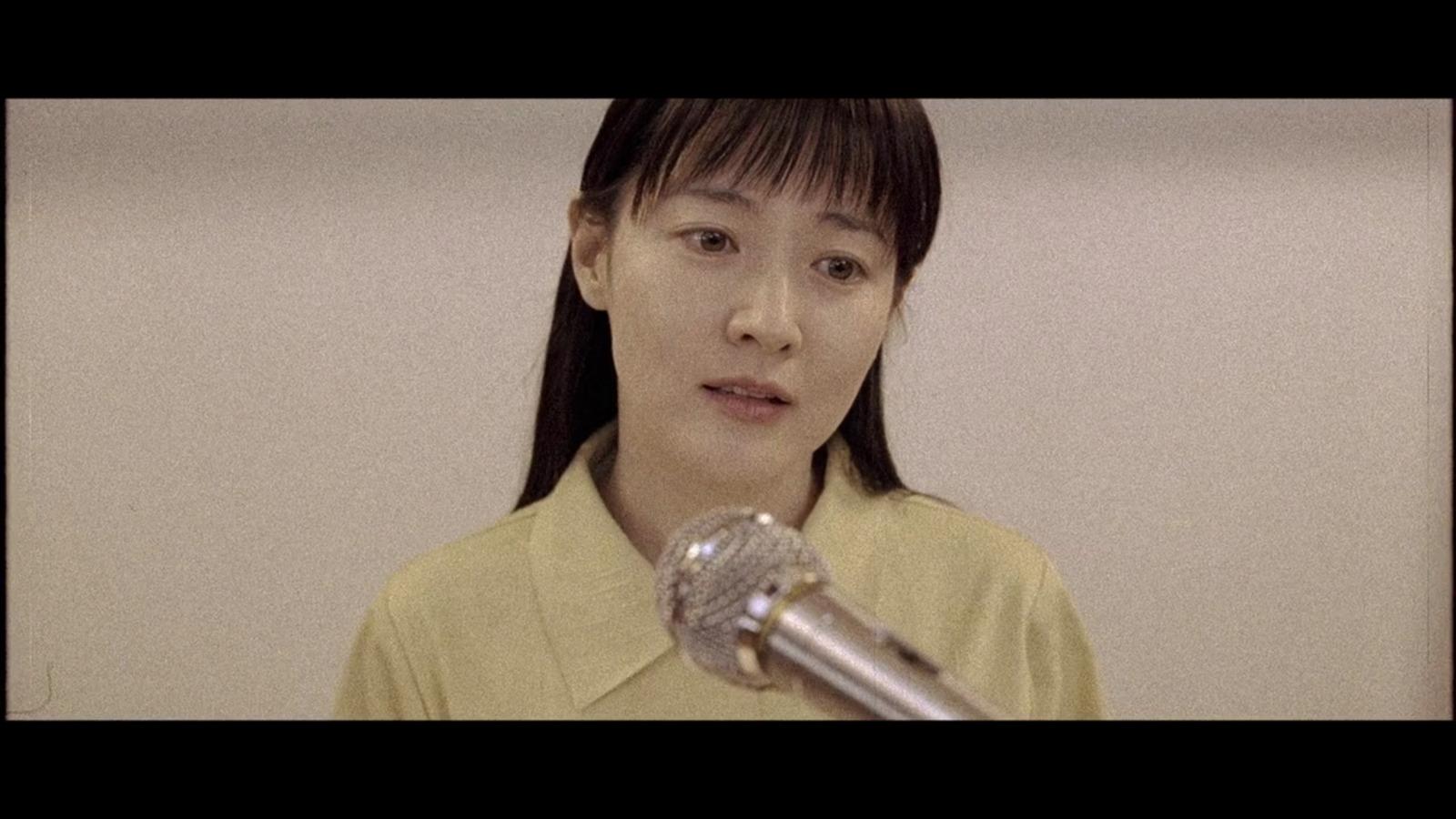 a woman holding a microphone in front of her face