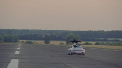 a car driving down a road with a person on top of it