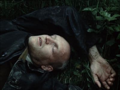 a man laying on the ground in the grass