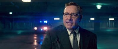 a man in a suit and tie standing in a parking garage
