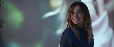 a woman standing in front of a projection screen