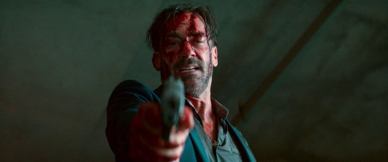 a man pointing a gun at the camera