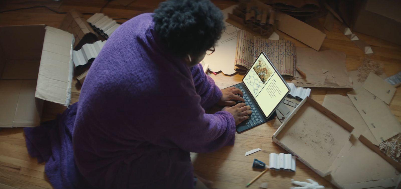 a woman sitting at a table using a laptop computer