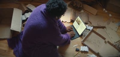 a woman sitting at a table using a laptop computer
