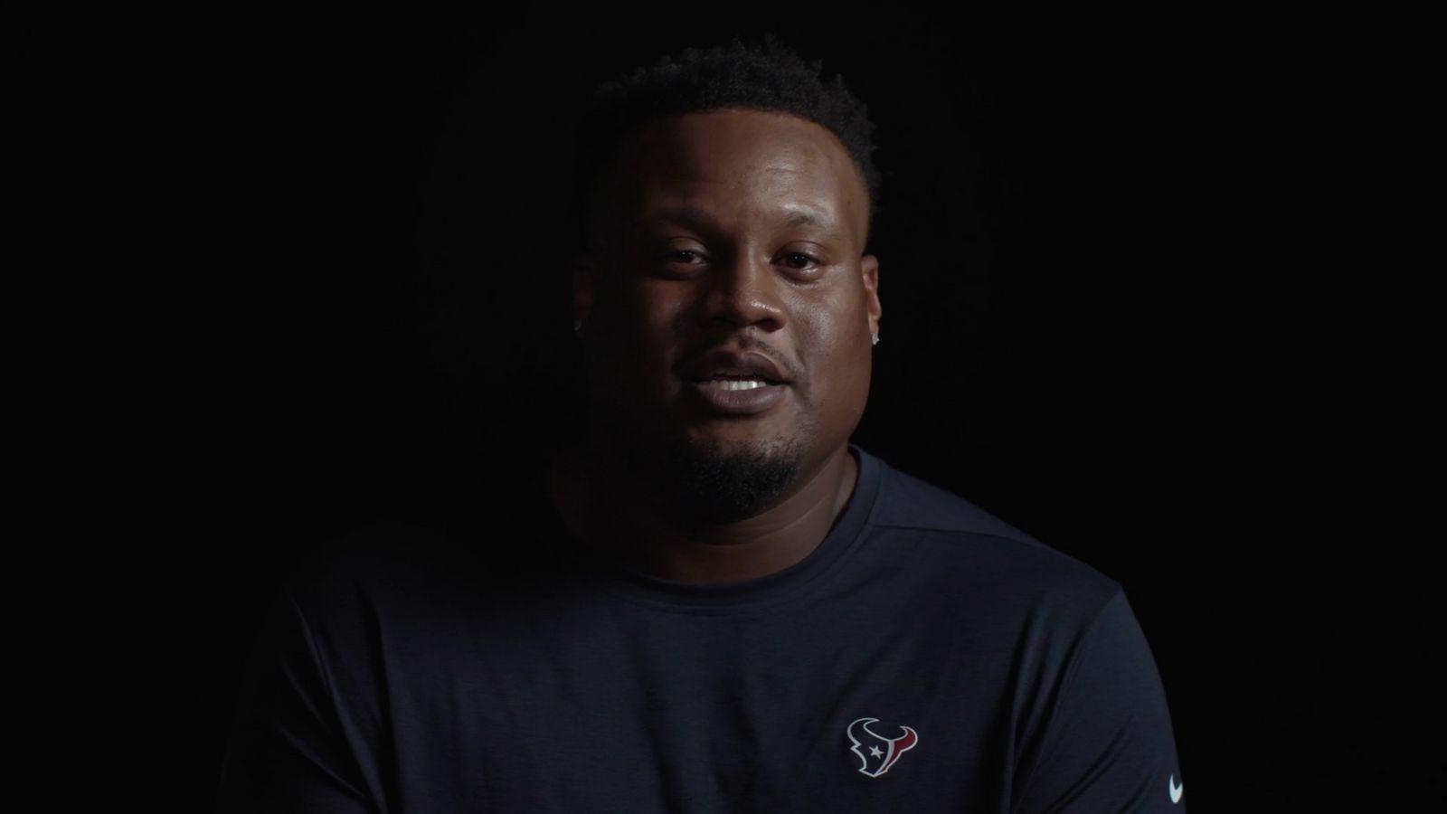 a man in a black shirt is looking at the camera