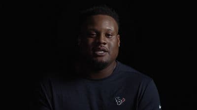 a man in a black shirt is looking at the camera