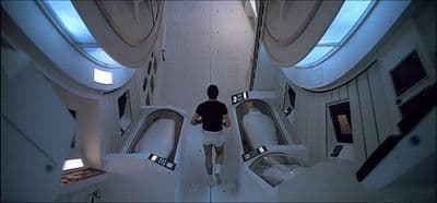 a woman is walking down a narrow hallway