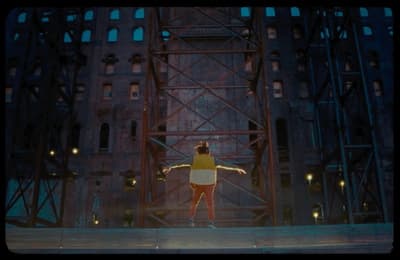 a person standing on a stage in front of a building
