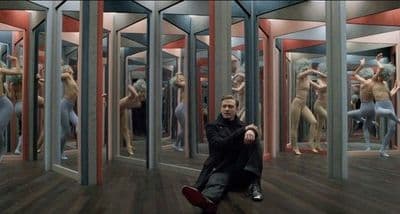 a man sitting on the floor in front of a mirror