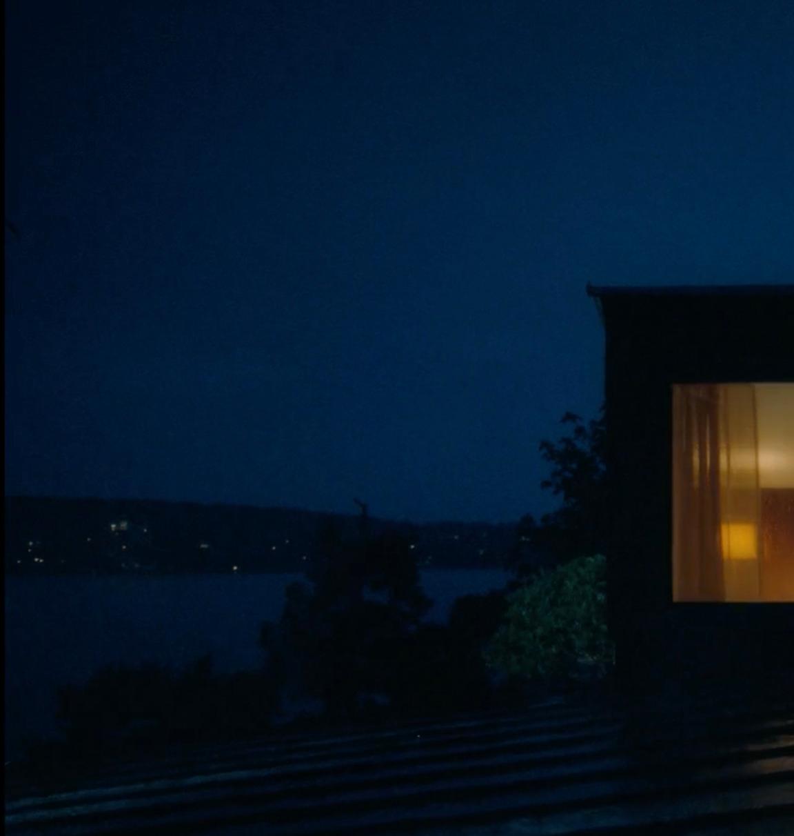 a couple of people standing outside of a building at night