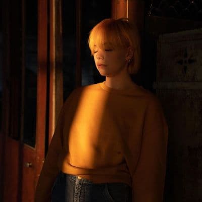 a woman standing in a room with her eyes closed