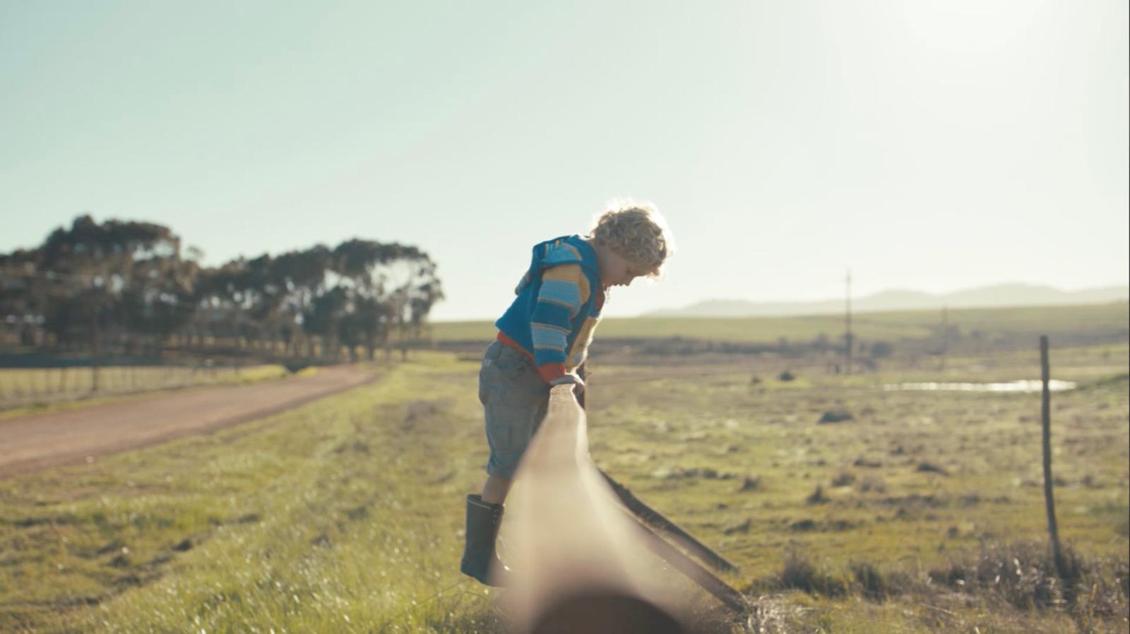 a man standing next to a long pipe in a field