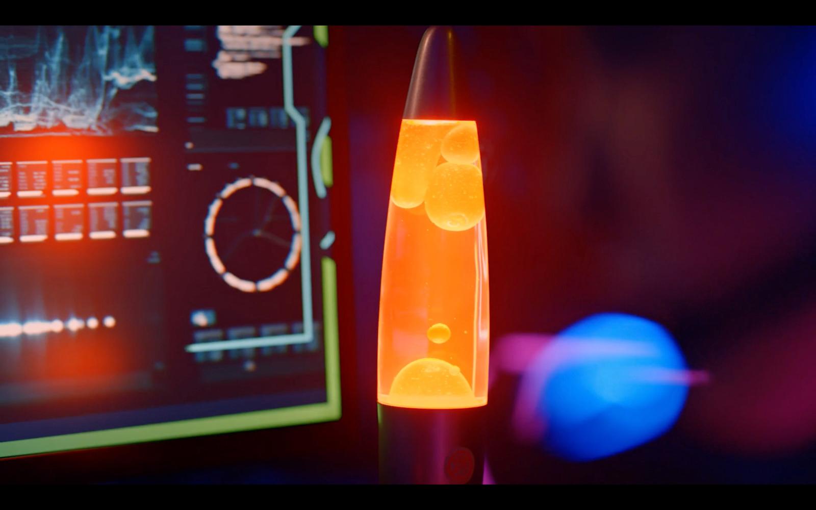 a close up of a lava lamp in front of a computer screen