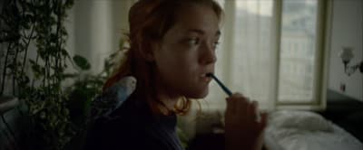 a woman brushing her teeth with a toothbrush