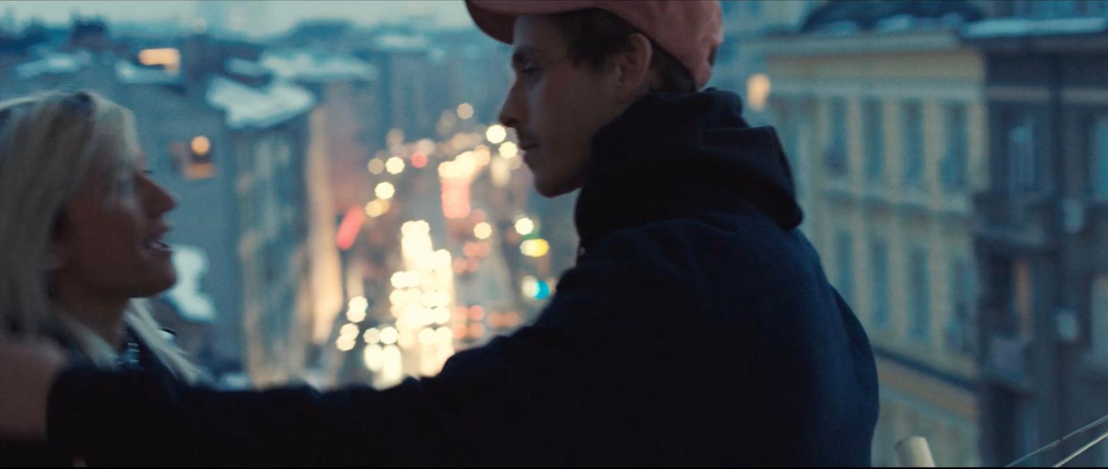 a man standing next to a woman on top of a building