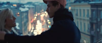 a man standing next to a woman on top of a building
