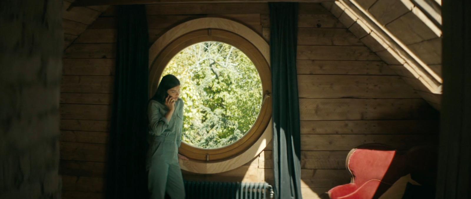 a woman standing in front of a round window