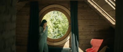 a woman standing in front of a round window