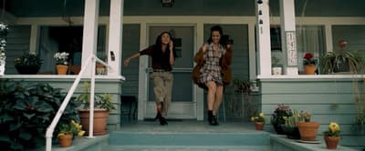 a couple of people that are standing outside of a house