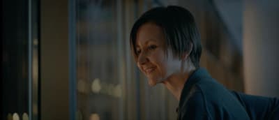 a woman standing in front of a window with a smile on her face