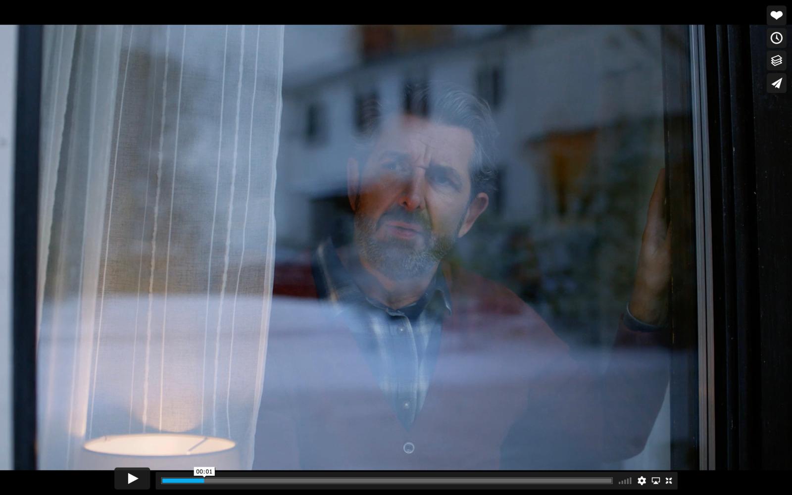 a man looking out of a window at a building