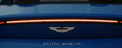a close up of the tail light of a blue sports car