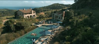 an aerial view of a house with a pool in the foreground