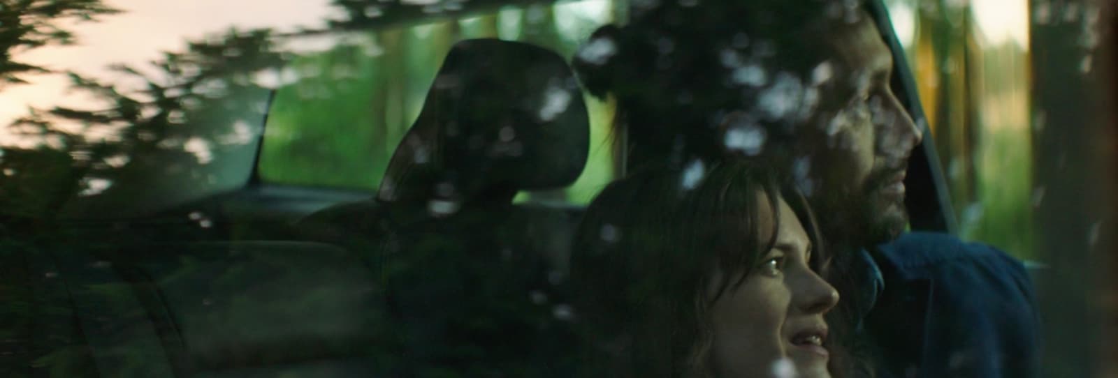 a man and a woman are seen through the window of a car