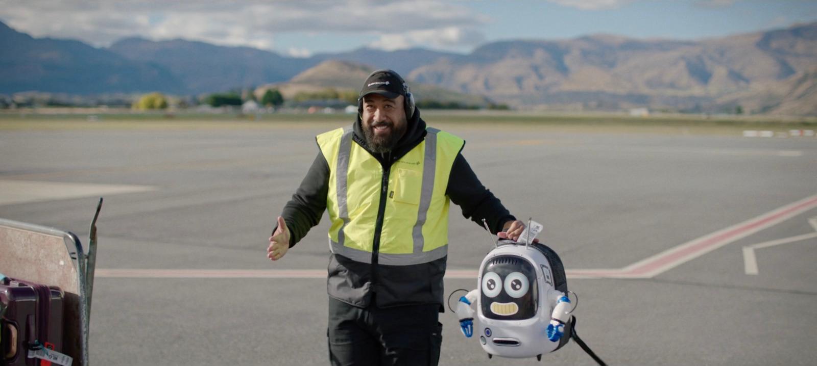 a man in a safety vest holding a luggage bag