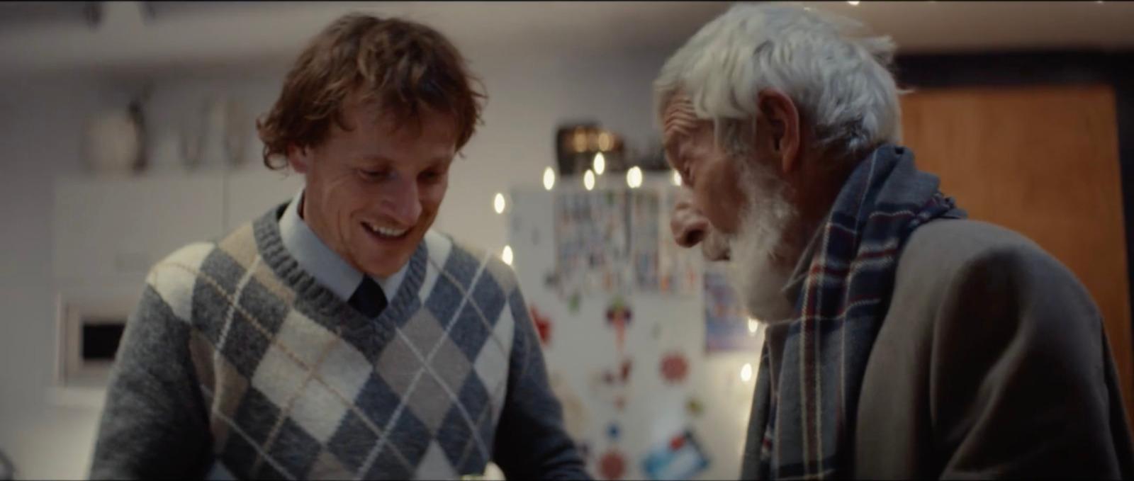 a man standing next to an older man in a kitchen