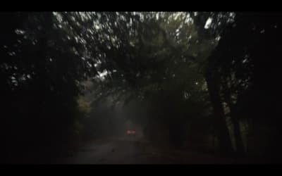 a car driving down a road in the dark
