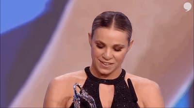 a woman in a black dress holding an award