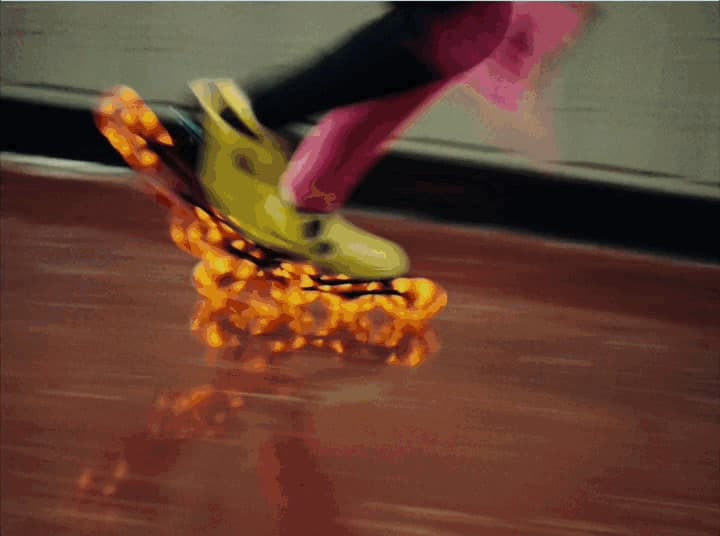 a person riding a roller skate on a wooden floor
