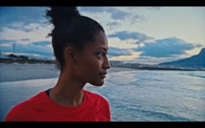 a woman standing in front of a body of water