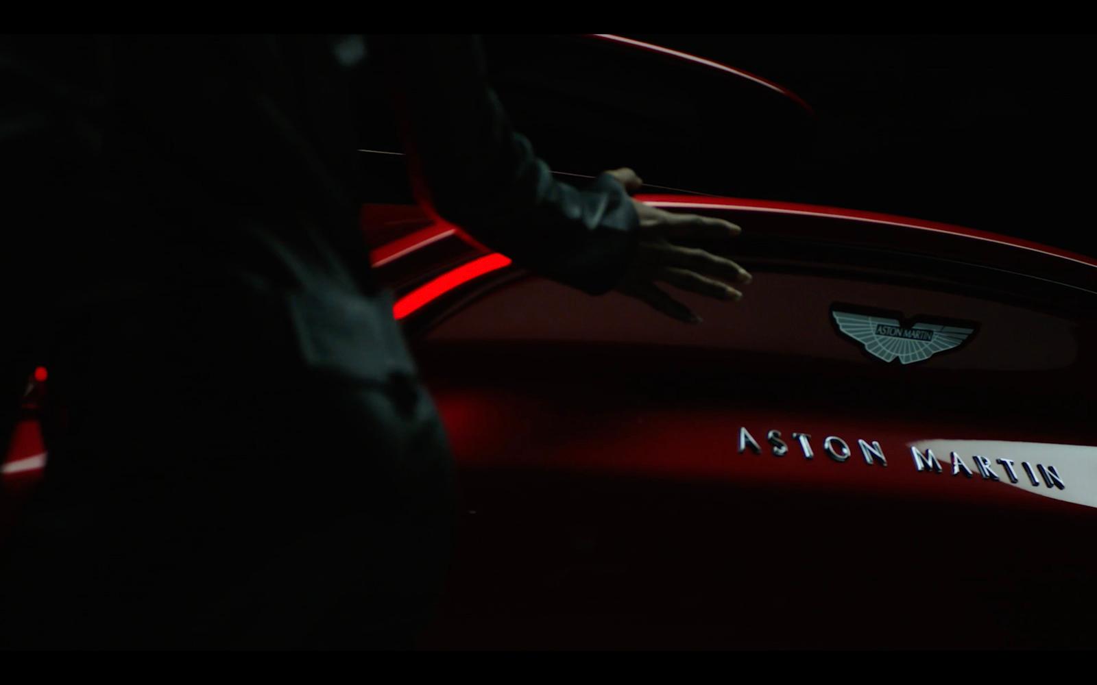 a man standing next to a red car in the dark