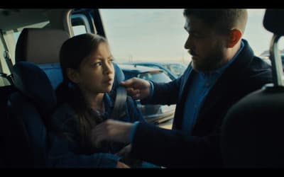 a man helping a little girl get in the car