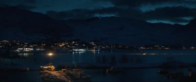 a night time view of a town and a lake