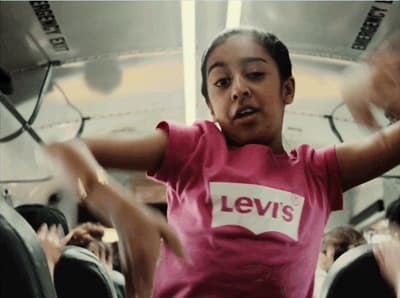 a young girl in a pink levi's t - shirt dancing