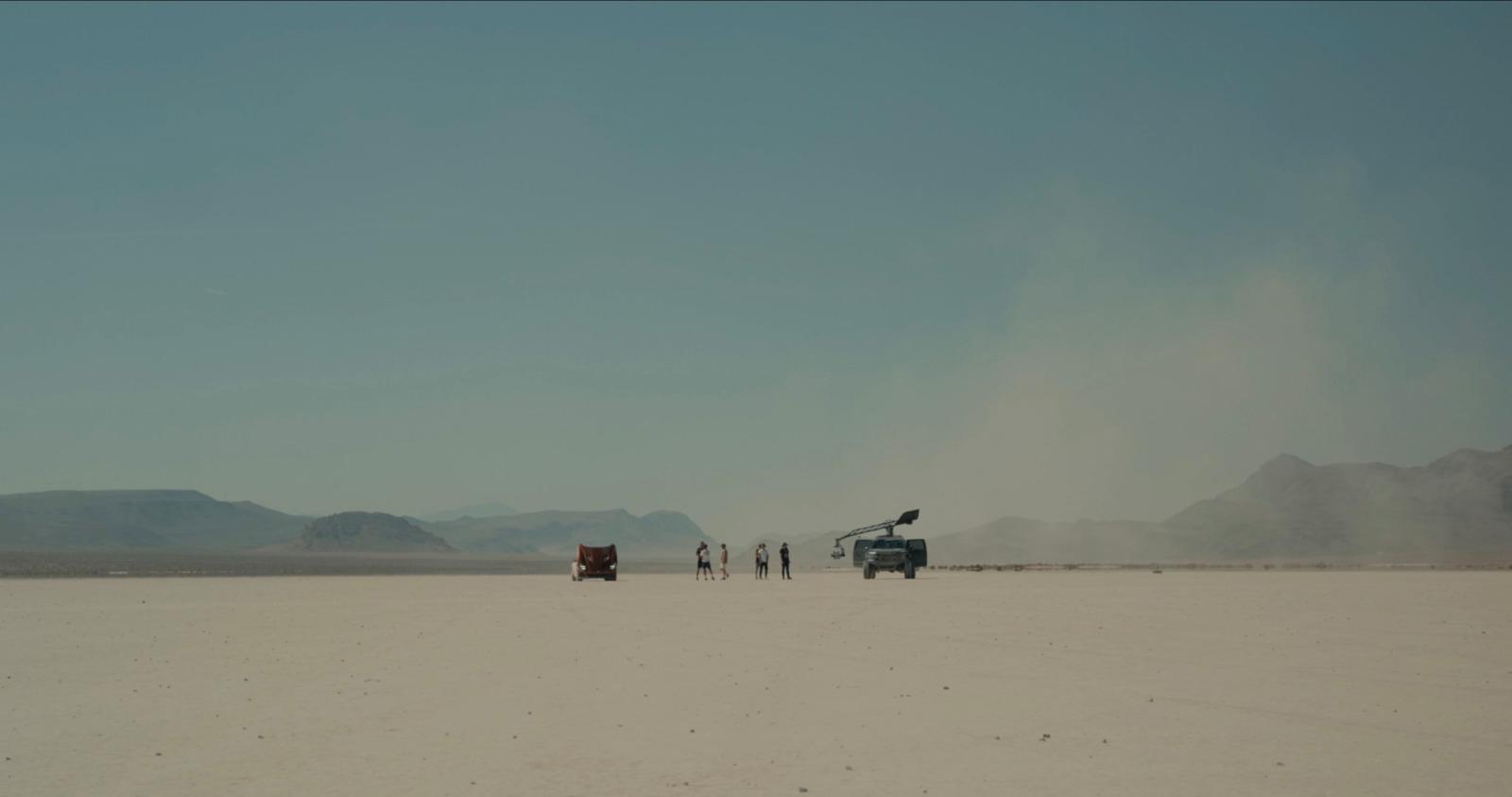 a group of people standing in the middle of a desert
