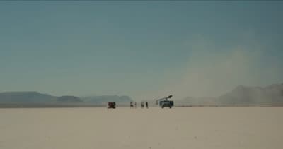 a group of people standing in the middle of a desert