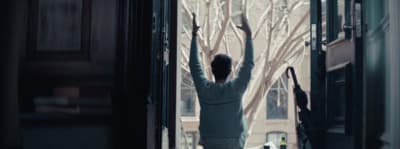 a woman standing in a doorway with her arms in the air