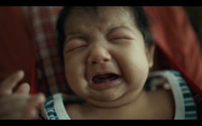 a baby crying while sitting in a chair