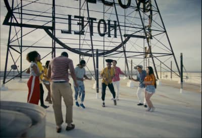 a group of people walking past a hotel sign