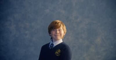 a young boy wearing a sweater and tie