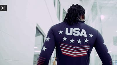 a man with dreadlocks walking down a hallway